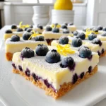 Für die leckeren Blueberry Lemon Cheesecake Bars benötigst du folgende Zutaten: - 1 ½ Tassen Graham-Cracker-Brösel - ½ Tasse ungesalzene Butter, geschmolzen - 2 Esslöffel Zucker - 450 g Frischkäse, weich - 200 g Zucker - 2 große Eier - 1 Teelöffel Vanilleextrakt - 2 Esslöffel Zitronensaft - Schale von 1 Zitrone - 1 ½ Tassen frische Blaubeeren - 1 Esslöffel Maisstärke Diese Zutaten ergeben eine köstliche Mischung aus süß und sauer, die jedem gefällt. Du kannst einige Zutaten ersetzen, wenn du willst. Hier sind einige Vorschläge: - Verwende Kekse statt Graham-Cracker, wenn du magst. - Kokosöl kann die Butter ersetzen. - Wenn du keinen Frischkäse hast, probiere Ricotta oder Quark. - Für eine vegane Option nutze pflanzlichen Frischkäse. Diese Alternativen sind perfekt, wenn du spezielle Wünsche oder Allergien hast. Frische Blaubeeren sind wichtig für den besten Geschmack. Hier sind einige Tipps: - Wähle reife, saftige Blaubeeren. Sie sollten fest und dunkelblau sein. - Achte darauf, dass sie keine Druckstellen haben. - Kaufe Blaubeeren, die im Kühlschrank gelagert wurden, um die Frische zu erhalten. Mit frischen Blaubeeren wird dein Cheesecake noch besser. Sie bringen Farbe und Geschmack in dein Dessert. Zuerst heizen wir den Ofen auf 160°C vor. Nimm eine Backform von 20x20 cm und lege sie mit Backpapier aus. Lass etwas Papier überhängen. So kannst du die Bars später leicht herausnehmen. In einer Schüssel vermischst du 1 ½ Tassen Graham-Cracker-Brösel, ½ Tasse geschmolzene Butter und 2 Esslöffel Zucker. Drücke die Mischung fest auf den Boden der Form. Sie sollte gleichmäßig verteilt sein. Backe die Kruste für 10 Minuten und lasse sie dann leicht abkühlen. Jetzt kommt der Spaß! In einer großen Schüssel schlägst du 450 g weichen Frischkäse mit 200 g Zucker. Mische das mit einem Handmixer, bis es glatt ist. Füge dann zwei große Eier nacheinander hinzu. Rühre gut nach jedem Ei. Jetzt kommt der Zitronengeschmack. Rühre einen Teelöffel Vanilleextrakt, 2 Esslöffel Zitronensaft und die Schale von einer Zitrone unter. In einer anderen Schüssel wälze 1 ½ Tassen Blaubeeren in 1 Esslöffel Maisstärke. Das hilft, dass sie nicht sinken. Hebe die Blaubeeren vorsichtig unter die Frischkäsemischung. Gieße die Füllung über die abgekühlte Kruste. Verteile sie gleichmäßig. Backe die Bars für 35-40 Minuten. Die Mitte sollte fest, aber noch leicht wackeln. Nach dem Backen lass die Form auf Raumtemperatur abkühlen. Stelle sie dann für mindestens 4 Stunden in den Kühlschrank. Am besten über Nacht. Nach dem Kühlen nimm die Bars mit dem Überhang aus der Form. Schneide sie in Quadrate und serviere sie. Ein häufiger Fehler ist, die Frischkäsemischung zu lange zu schlagen. Dadurch wird sie zu luftig und kann Risse bekommen. Mische alles gerade so lange, bis es glatt ist. Achte auch darauf, die Blaubeeren nicht zu zerdrücken, wenn du sie unterhebst. So bleiben sie ganz und verleihen den Bars Struktur. Für eine perfekte Konsistenz ist es wichtig, die Bars ausreichend lange im Kühlschrank zu kühlen. Mindestens vier Stunden sind nötig, aber über Nacht ist ideal. So wird die Füllung fest und lässt sich gut schneiden. Die Mischung sollte vor dem Backen leicht wackeln, wenn du die Form bewegst. Das gibt die richtige Textur. Um die Bars ansprechend zu servieren, bestäube sie mit Puderzucker. Dekoriere sie mit frischen Blaubeeren und einer Zitronenscheibe. Dies sorgt für einen frischen und einladenden Look. Du kannst auch einen Klecks Schlagsahne dazugeben. Dies macht das Dessert noch cremiger und leckerer. {{image_4}} Ich liebe es, mit verschiedenen Früchten zu experimentieren. Blaubeeren sind großartig, aber du kannst auch andere Früchte verwenden. Himbeeren, Erdbeeren oder sogar Pfirsiche passen gut. Wähle frische oder gefrorene Früchte. Wenn du gefrorene Früchte verwendest, tau sie vorher auf. Achte darauf, die Früchte in Maisstärke zu wälzen. So bleiben sie in der Füllung besser verteilt. Wenn du eine glutenfreie Option möchtest, ist das einfach! Ersetze die Graham-Cracker durch glutenfreie Kekse oder Haferflocken. Mische die glutenfreien Brösel mit geschmolzener Butter und Zucker. Der Rest des Rezepts bleibt gleich. So bekommst du immer noch die leckere Kruste ohne Gluten. Für eine vegane Version kannst du Frischkäse durch pflanzliche Alternativen ersetzen. Kokosnuss- oder Cashew-Frischkäse funktioniert gut. Anstelle von Eiern kannst du Apfelmus oder Leinsamen verwenden. Mische einen Esslöffel Leinsamen mit drei Esslöffeln Wasser und lasse es kurz quellen. Das gibt eine ähnliche Konsistenz. Diese Änderungen machen deine Bars vegan, aber trotzdem lecker! Um die Blaubeer-Zitronen-Cheesecake-Bars frisch zu halten, lege sie in den Kühlschrank. Verwende einen luftdichten Behälter, um die Bars vor Gerüchen zu schützen. Wenn du sie im Kühlschrank aufbewahrst, bleiben sie bis zu einer Woche lecker und frisch. Stelle sicher, dass sie gut gekühlt sind, bevor du sie servierst. Wenn du die Bars länger aufbewahren möchtest, kannst du sie einfrieren. Schneide die Bars in Stücke und lege sie in einen Gefrierbeutel. Achte darauf, die Luft so gut wie möglich herauszudrücken. So bleiben sie bis zu drei Monate haltbar. Zum Auftauen lege die Bars einfach über Nacht in den Kühlschrank. So bleiben die Aromen erhalten. Die Haltbarkeit der Cheesecake-Bars hängt von der Lagerung ab. Im Kühlschrank hält sich eine ungeöffnete Portion bis zu einer Woche. Einfrieren verlängert die Haltbarkeit auf drei Monate. Achte darauf, die Bars vor dem Verzehr gut aufzutauen. So schmecken sie wie frisch gebacken. Die Zubereitung dauert etwa 15 Minuten. Das Backen braucht rund 35 bis 40 Minuten. Vergessen Sie nicht, die Bars nach dem Backen für mindestens 4 Stunden im Kühlschrank zu kühlen. Insgesamt sind es also etwa 5 Stunden, bis Sie die Bars genießen können. Ja, Sie können gefrorene Blaubeeren verwenden. Achten Sie darauf, sie vor der Verwendung etwas auftauen zu lassen. Tupfen Sie sie danach trocken. So bleibt die Füllung nicht zu flüssig. Sie können Quark oder veganen Frischkäse verwenden. Diese Alternativen geben einen ähnlichen Geschmack. Achten Sie darauf, die Konsistenz gut zu prüfen. In diesem Artikel haben wir die wichtigsten Zutaten und Schritte zur Zubereitung von Cheesecake-Bars besprochen. Wir haben die Hauptbestandteile, Ersatzstoffe, und Tipps für frische Blaubeeren behandelt. Die Schritt-für-Schritt-Anleitung war klar und einfach. Zudem gab es hilfreiche Tipps, um häufige Fehler zu vermeiden. Denken Sie daran, Variationen auszuprobieren, um Ihr Rezept anzupassen. Achten Sie auch auf die richtige Lagerung, damit Ihre Bars frisch bleiben. Mit diesen Tipps werden Ihre Cheesecake-Bars ein Hit!