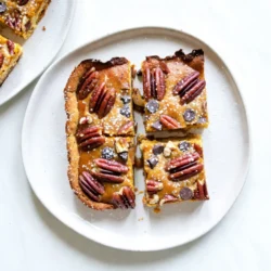 Für die Kürbis-Pekan-Kuchen-Riegel brauchst du folgende Hauptzutaten: - 1 ½ Tassen Allzweckmehl - ½ Tasse brauner Zucker - ½ Tasse ungesalzene Butter, weich - 1 Tasse Kürbispüree aus der Dose - 1 Tasse gesüßte kondensierte Milch - ½ Tasse weißer Zucker - 2 große Eier - 1 Teelöffel Vanilleextrakt - 1 Tasse Pekannüsse, grob gehackt Diese Zutaten machen die Riegel lecker und cremig. Das Kürbispüree gibt den Riegeln das besondere Aroma. Für den Boden der Riegel benötigst du: - 1 ½ Tassen Allzweckmehl - ½ Tasse brauner Zucker - ½ Tasse ungesalzene Butter, weich Diese Zutaten sorgen für eine feste und süße Basis. Der Boden sollte goldbraun sein, um das beste Ergebnis zu erzielen. Die Gewürze machen diese Riegel einzigartig. Du brauchst: - 1 Teelöffel gemahlener Zimt - ½ Teelöffel gemahlene Muskatnuss - ½ Teelöffel gemahlener Ingwer - ½ Teelöffel Salz Diese Aromen geben den Riegeln den perfekten Herbstgeschmack. Sie machen die Riegel warm und einladend. {{ingredient_image_2}} Heize deinen Ofen auf 175 °C vor. Fette eine 9x13 Zoll große Backform ein oder lege sie mit Backpapier aus. Dies hilft dir, die Riegel später leicht herauszunehmen. In einer mittleren Schüssel mische 1 ½ Tassen Allzweckmehl und ½ Tasse braunen Zucker. Füge ½ Tasse weiche ungesalzene Butter hinzu. Rühre die Mischung, bis sie groben Krümeln ähnelt. Drücke diese Mischung gleichmäßig auf den Boden der Backform. Backe den Boden für 15-18 Minuten, bis er leicht goldbraun ist. Lass ihn einige Minuten abkühlen. In einer großen Schüssel verquirle 1 Tasse Kürbispüree, 1 Tasse gesüßte kondensierte Milch, ½ Tasse weißen Zucker, 2 große Eier, 1 Teelöffel Vanilleextrakt, 1 Teelöffel gemahlenen Zimt, ½ Teelöffel gemahlene Muskatnuss, ½ Teelöffel gemahlenen Ingwer und ½ Teelöffel Salz. Rühre, bis die Mischung glatt ist. Füge 1 Tasse grob gehackte Pekannüsse und eventuell ½ Tasse Mini-Schokoladenstückchen hinzu. Gieße die Füllung gleichmäßig über den vorgebackenen Boden. Backe die Riegel für 25-30 Minuten. Sie sind bereit, wenn ein Zahnstocher sauber herauskommt. Lass sie komplett abkühlen und kühl sie dann 1-2 Stunden im Kühlschrank. Schneide die Riegel nach dem Kühlen in Stücke. Serviere sie gekühlt oder bei Raumtemperatur. Die Konsistenz der Kürbis-Pekan-Kuchen-Riegel ist wichtig. Um sie perfekt zu machen, achten Sie darauf, die Füllung gut zu mischen. Verwenden Sie eine große Schüssel und einen Schneebesen, um Klumpen zu vermeiden. Die Mischung sollte glatt sein, bevor Sie die Pekannüsse hinzufügen. Ein weiterer Tipp ist, die Füllung nicht zu überbacken. Überprüfen Sie die Riegel nach 25 Minuten. Ein Zahnstocher sollte sauber herauskommen, wenn die Füllung fest ist. Nach dem Backen lassen Sie die Riegel in der Form abkühlen. Dies dauert etwa 30 Minuten. Danach stellen Sie die Form in den Kühlschrank für 1-2 Stunden. Kühlen hilft, die Riegel fest zu machen. Wenn Sie schneiden, verwenden Sie ein scharfes Messer. Schneiden Sie die Riegel gleichmäßig, um eine schöne Präsentation zu erzielen. Vermeiden Sie es, die Riegel zu warm zu schneiden, da sie zerfallen können. Eine schöne Präsentation macht viel aus. Schneiden Sie die Riegel in quadratische Stücke. Legen Sie sie auf einen dekorativen Teller. Garnieren Sie die Riegel mit einem Hauch Schlagsahne und etwas Zimt. Ein bisschen Puderzucker oben drauf sieht auch toll aus. Diese Tipps machen Ihre Riegel nicht nur lecker, sondern auch ansprechend! Pro Tipps Verwenden Sie frisches Kürbispüree: Für einen intensiveren Geschmack können Sie frisches Kürbispüree statt der Dose verwenden. Röstet den Kürbis vorher, um die Süße zu intensivieren. Variieren Sie die Nüsse: Experimentieren Sie mit verschiedenen Nüssen wie Walnüssen oder Mandeln, um den Riegeln eine andere Textur und Geschmack zu verleihen. Perfekte Kühlung: Lassen Sie die Riegel vollständig abkühlen, bevor Sie sie schneiden. Dies hilft, die Struktur zu festigen und ein sauberes Schneiden zu gewährleisten. Garnierungen hinzufügen: Für zusätzlichen Geschmack und eine schöne Präsentation können Sie die Riegel vor dem Servieren mit karamellisierten Pekannüssen oder Schokoladensauce garnieren. {{image_4}} Ein toller Zusatz sind Mini-Schokoladenstückchen. Sie geben den Riegeln eine süße Note. Fügen Sie sie einfach in die Füllung hinzu. Ein Drittel Tasse reicht oft aus. Sie schmelzen und verbinden sich mit dem Kürbis. So entsteht ein leckerer Kontrast zu den Nüssen. Pekannüsse sind klassisch, aber auch andere Nüsse sind gut. Mandeln oder Walnüsse passen ebenfalls prima. Hacken Sie sie grob und mischen Sie sie in die Füllung. Für ein knuspriges Topping können Sie die Nüsse auch oben drauf streuen. So bekommen die Riegel eine schöne Textur. Für glutenfreie Riegel nutzen Sie einfach ein glutenfreies Mehl. Achten Sie darauf, das richtige Mehl zu wählen, das gut bindet. Für vegane Riegel ersetzen Sie die Eier durch Apfelmus oder Leinsamen. Die gesüßte kondensierte Milch kann durch eine pflanzliche Alternative ersetzt werden. So bleibt der Geschmack trotzdem toll. Kürbis-Pekan-Kuchen-Riegel lieben kühle und trockene Orte. Sie sollten in einem luftdichten Behälter aufbewahrt werden. So bleiben sie frisch und lecker. Vermeiden Sie Feuchtigkeit, da sie die Riegel matschig machen kann. Ein kühler Platz in der Küche ist ideal. Wenn Sie die Riegel länger aufbewahren möchten, legen Sie sie in den Kühlschrank. Sie bleiben dort bis zu einer Woche frisch. Für eine längere Lagerung können Sie die Riegel einfrieren. Wickeln Sie sie gut in Frischhaltefolie und legen Sie sie in einen Gefrierbeutel. So sind sie bis zu drei Monate haltbar. Lassen Sie sie vor dem Essen einfach bei Raumtemperatur auftauen. Die Riegel halten sich im Kühlschrank etwa eine Woche. Im Gefrierschrank sind sie bis zu drei Monate gut. Achten Sie darauf, dass Sie sie richtig lagern. So bleibt der Geschmack und die Konsistenz perfekt. Wenn die Riegel anfangen, seltsam zu riechen oder ihre Farbe ändern, sollten Sie sie wegwerfen. Du kannst die Riegel bis zu einer Woche im Kühlschrank aufbewahren. Stelle sicher, dass sie in einem luftdichten Behälter sind. So bleiben sie frisch und lecker. Wenn du sie länger aufbewahren willst, kannst du sie einfrieren. Sie halten sich im Gefrierfach bis zu drei Monate. Ja, frisches Kürbispüree ist eine tolle Option! Du musst den Kürbis zuerst kochen oder rösten und dann pürieren. Achte darauf, dass es nicht zu wässrig ist, da dies die Füllung beeinflussen kann. Frisches Püree hat einen tollen Geschmack. Lass die Riegel zuerst ganz abkühlen. Schneide sie dann in Stücke und lege sie in einen luftdichten Behälter. Wenn du ein paar Riegel übrig hast, kannst du sie auch zwischen Lagen Backpapier legen. Das verhindert, dass sie aneinander kleben. Zusammengefasst haben wir die Zutaten für Kürbis-Pekan-Kuchen-Riegel behandelt. Wir schauten uns die Hauptzutaten, die Backzutaten und die Gewürze an. Die Schritt-für-Schritt-Anleitung führte uns durch das Backen. Tipps zur Konsistenz und Präsentation helfen, die Riegel perfekt zu servieren. Variationen bieten Spaß beim Ausprobieren. Schließlich klärte ich Lagerungshinweise und häufige Fragen. Mit diesen Tipps kannst du leckere Riegel kreieren, die jeder liebt. Viel Spaß beim Backen!