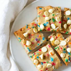 Für die Konfetti Zucker Cookie Bars brauchst du die folgenden Zutaten: - 2 ½ Tassen Weizenmehl - 1 Teelöffel Backpulver - ½ Teelöffel Natron - ½ Teelöffel Salz - ¾ Tasse ungesalzene Butter, weich - 1 Tasse Kristallzucker - ½ Tasse brauner Zucker, gepackt - 2 große Eier - 1 Teelöffel Vanilleextrakt - 1 Teelöffel Mandelextrakt - ¾ Tasse Regenbogenstreusel (plus zusätzlich zum Dekorieren) - 1 Tasse weiße Schokoladenstückchen Die Hauptbestandteile der Riegel sind Weizenmehl, Butter und Zucker. Weizenmehl gibt Struktur. Butter sorgt für den cremigen Geschmack. Kristallzucker und brauner Zucker bringen Süße und Feuchtigkeit. Eier helfen beim Binden. Die Aromen von Vanille- und Mandelextrakt geben den Riegeln einen besonderen Kick. Regenbogenstreusel machen die Bars bunt und fröhlich. Weiße Schokoladenstückchen bringen eine süße Note und cremige Textur. - Butter: Wähle ungesalzene Butter für einen klaren Geschmack. Achte darauf, dass sie weich ist, damit sie sich gut vermischen lässt. - Zucker: Verwende frischen Kristall- und braunen Zucker. Alter Zucker kann klumpig sein und die Textur beeinträchtigen. - Eier: Frische Eier sind wichtig. Sie geben den Riegeln die richtige Konsistenz. - Streusel: Suche nach hochwertigen Regenbogenstreuseln. Sie sollten leuchtende Farben haben und gut im Teig halten. Hochwertige Zutaten sorgen für einen besseren Geschmack und eine schönere Textur. So werden deine Konfetti Zucker Cookie Bars ein echter Hit! {{ingredient_image_2}} Zuerst heize deinen Ofen auf 180°C vor. Dies sorgt dafür, dass die Riegel gleichmäßig backen. Nimm eine 9x13 Zoll große Backform. Lege sie mit Backpapier aus. Lass das Papier an den Seiten überstehen. So kannst du die Riegel später leicht herausnehmen. In einer mittelgroßen Schüssel vermische das Weizenmehl, Backpulver, Natron und Salz. Rühre alles gut um und stelle die Mischung beiseite. In einer großen Schüssel schlage die weiche Butter, den Kristallzucker und den braunen Zucker mit einem Handmixer. Mische sie etwa 3 Minuten lang, bis die Mischung leicht und luftig ist. Füge dann die Eier, den Vanilleextrakt und den Mandelextrakt hinzu. Mische alles gut, bis es gut kombiniert ist. Gib nach und nach die trockenen Zutaten zur feuchten Mischung. Rühre auf niedriger Stufe, bis alles gerade so vermengt ist. Verwende einen Spatel, um die Regenbogenstreusel und die weißen Schokoladenstückchen vorsichtig unter den Teig zu heben. Achte darauf, nicht zu lange zu mischen. Gieße den Keksteig in die vorbereitete Backform. Streiche ihn gleichmäßig glatt. Bestreue die Oberfläche mit zusätzlichen Streuseln. Backe die Riegel im Ofen für 20-25 Minuten. Sie sind fertig, wenn die Ränder leicht goldbraun sind. Ein Zahnstocher sollte sauber herauskommen, wenn du ihn in die Mitte steckst. Lass die Kekse in der Form etwa 10 Minuten abkühlen. Danach hebe sie mit dem Backpapier auf ein Kuchengitter. Lass sie dort vollständig abkühlen. Nach dem Abkühlen schneide die Riegel in Quadrate. Jetzt sind sie bereit zum Servieren! Ein häufiger Fehler ist, die Butter nicht weich genug zu machen. Weiche Butter sorgt für die beste Textur der Riegel. Achte darauf, die trockenen Zutaten nicht zu lange zu mischen. Übermischung kann die Riegel hart machen. Lass die Kekse nach dem Backen auch richtig abkühlen. Das gibt ihnen die richtige Konsistenz. Die ideale Temperatur für das Backen ist 180°C. Backe die Riegel 20 bis 25 Minuten. Die Ränder sollten leicht goldbraun sein. Überprüfe die Riegel mit einem Zahnstocher. Wenn er sauber herauskommt, sind sie fertig. Kürzere Backzeiten können zu einem teigigen Kern führen. Jeder Ofen ist anders. Ein Umluftofen kann die Backzeit verkürzen. Prüfe die Riegel nach 15 Minuten. Bei älteren Modellen kann die Temperatur schwanken. Ein Ofenthermometer hilft, die genaue Temperatur zu finden. Wenn du den Ofen richtig kennst, kannst du die beste Backzeit finden. Pro Tipps Mehl sieben: Durch das Sieben des Weizenmehls wird es luftiger und die Kekse werden zarter. Butter weich machen: Stelle sicher, dass die Butter wirklich weich ist, um eine cremige Textur zu erreichen und die Zutaten gut zu vermengen. Regenbogenstreusel hinzufügen: Füge die Streusel vorsichtig hinzu, um ihre Farben lebendig zu halten und ein gleichmäßiges Verteilen zu gewährleisten. Richtig abkühlen: Lass die Riegel in der Form abkühlen, bevor du sie herausnimmst, um ein Brechen zu vermeiden. {{image_4}} Wenn du die weißen Schokoladenstückchen nicht magst, gibt es viele tolle Alternativen. Du kannst Milchschokolade oder Zartbitterschokolade verwenden. Diese Sorten bringen einen anderen Geschmack. Auch Nüsse sind eine gute Wahl. Walnüsse oder Mandeln fügen einen knackigen Biss hinzu. Denk daran, die Menge der Schokolade oder Nüsse gleich zu halten. Für glutenfreie Riegel kannst du das Weizenmehl durch eine glutenfreie Mischung ersetzen. Achte darauf, dass die Mischung für Backen geeignet ist. Das sorgt für die beste Textur. Die anderen Zutaten bleiben gleich. Folge einfach der gleichen Anleitung. Diese Riegel sind dann für alle geeignet. Streusel sind der Schlüssel zu bunten Riegeln. Du kannst verschiedenen Farben und Formen wählen. Zum Beispiel, Herzstreusel für den Valentinstag oder Kürbisse für Halloween. Bunte Streusel machen die Riegel noch fröhlicher. Du kannst auch essbare Glitzer hinzufügen. Das gibt einen besonderen Glanz. Experimentiere mit verschiedenen Kombinationen für mehr Spaß! Um die Frische deiner Konfetti Zucker Cookie Bars zu bewahren, lagere sie in einem luftdichten Behälter. Das hilft, die Feuchtigkeit zu halten. Achte darauf, dass die Riegel vollständig abgekühlt sind, bevor du sie verpackst. So vermeidest du, dass sie matschig werden. Du kannst auch etwas Pergamentpapier zwischen die Riegel legen. Das schützt sie und verhindert ein Festkleben. Falls du mehr Riegel gemacht hast, kannst du sie einfrieren. Schneide die Riegel in Portionen und lege sie in einen gefrierfesten Beutel. Drücke die Luft heraus, bevor du ihn schließt. So bleiben die Riegel bis zu drei Monate frisch. Zum Auftauen, lege sie einfach für ein paar Stunden bei Raumtemperatur auf die Theke. Wenn du es eilig hast, kannst du sie auch in der Mikrowelle auftauen. Achte darauf, sie nicht zu lange zu erhitzen, sonst werden sie hart. Im Kühlschrank halten die Konfetti Zucker Cookie Bars bis zu einer Woche. Stelle sicher, dass der Behälter gut verschlossen ist. So bleiben sie weich und lecker. Wenn du die Riegel länger aufbewahren möchtest, ist das Einfrieren die beste Option. Frisch gebacken sind sie immer am besten, aber die Riegel schmecken auch nach ein paar Tagen noch gut. Du kannst die Konfetti-Zucker-Kekse-Riegel bis zu einer Woche aufbewahren. Lagere sie in einem luftdichten Behälter. So bleiben sie frisch und lecker. Wenn du die Riegel länger aufbewahren möchtest, friere sie ein. So bleiben sie bis zu drei Monate gut. Achte darauf, sie in Portionen zu verpacken, damit du sie leicht entnehmen kannst. Ja, du kannst die Riegel vegan machen. Ersetze die Eier durch Apfelmus oder Leinsamen. Verwende vegane Butter anstelle von ungesalzener Butter. Auch achte darauf, vegane Schokoladenstückchen zu verwenden. So bleiben die Riegel lecker und sind für alle geeignet. Um die Riegel schön zu dekorieren, verwende mehr Regenbogenstreusel. Streue sie nach dem Backen auf die warme Oberfläche. Das gibt einen bunten Look. Du kannst auch Zuckerguss hinzufügen, um sie noch süßer zu machen. Ein kleiner Spritzer Zuckerguss macht sie festlich. Verwende bunte Muffinförmchen für eine spaßige Präsentation. Zusammenfassend haben wir die besten Zutaten für diese Konfetti-Zucker-Kekse-Riegel betrachtet. Wir haben gelernt, wie man sie richtig zubereitet und welche häufigen Fehler man vermeiden sollte. Tipps zur Lagerung sorgen dafür, dass die Riegel frisch bleiben. Denken Sie daran, dass Variationen den Spaß beim Backen erhöhen können. Probieren Sie verschiedene Zutaten und Dekorationen aus. So machen Sie Ihr Rezept noch interessanter. Jetzt sind Sie bereit, Ihre eigenen leckeren Riegel zu kreieren!